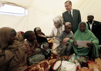 Turkey's Prime Minister Recep Tayyip Erdogan (top) and his wife Emine Erdogan (C) visit a camp for displaced people as they are accompanied by Somalia's President Sheikh Sharif Ahmed (R) in Mogadishu August 19, 2011. Erdogan and his family visit Somalia, which is grappling to quash an Islamist rebellion that has hampered the delivery of food aid across swathes of its southern and central regions. REUTERS/Umit Bektas (SOMALIA - Tags: POLITICS CIVIL UNREST DISASTER)