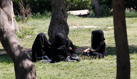 Veiled women sit as they chat in a garden in the northern province of Raqqa
